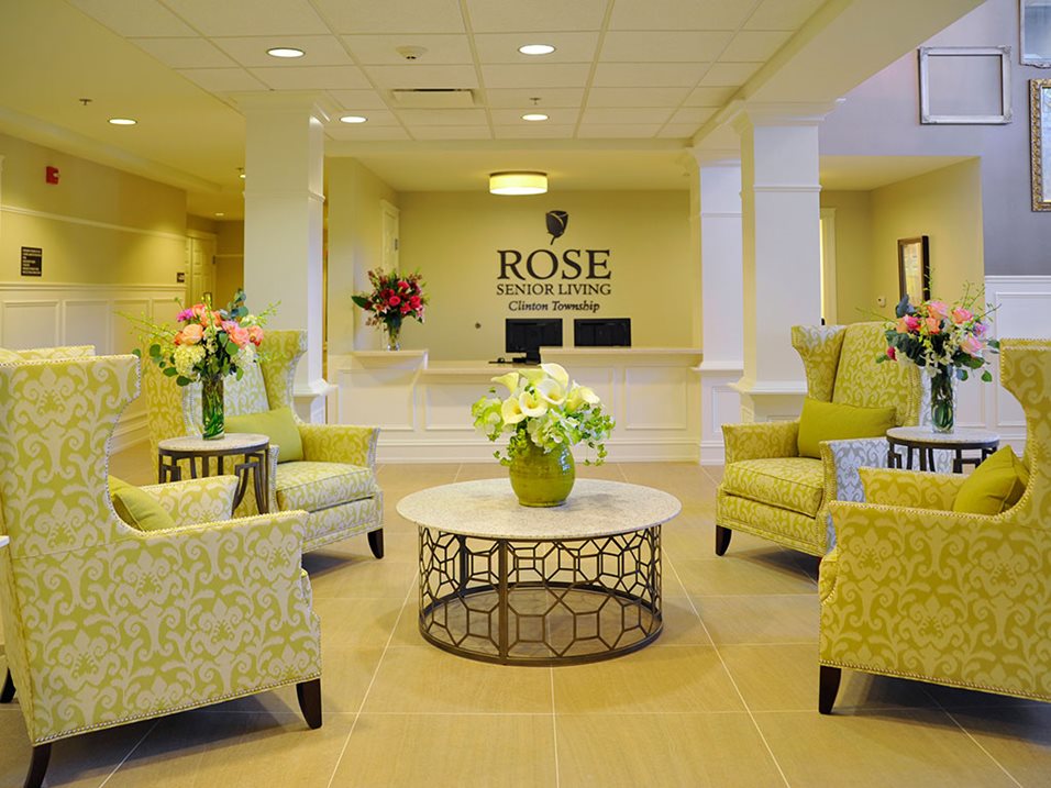 Lobby of Rose Senior Living, Clinton Township, with yellow armchairs and floral arrangements