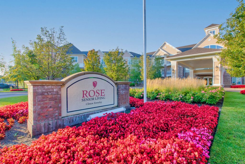 Rose Senior Living sign with lush landscaping and residential building in the background