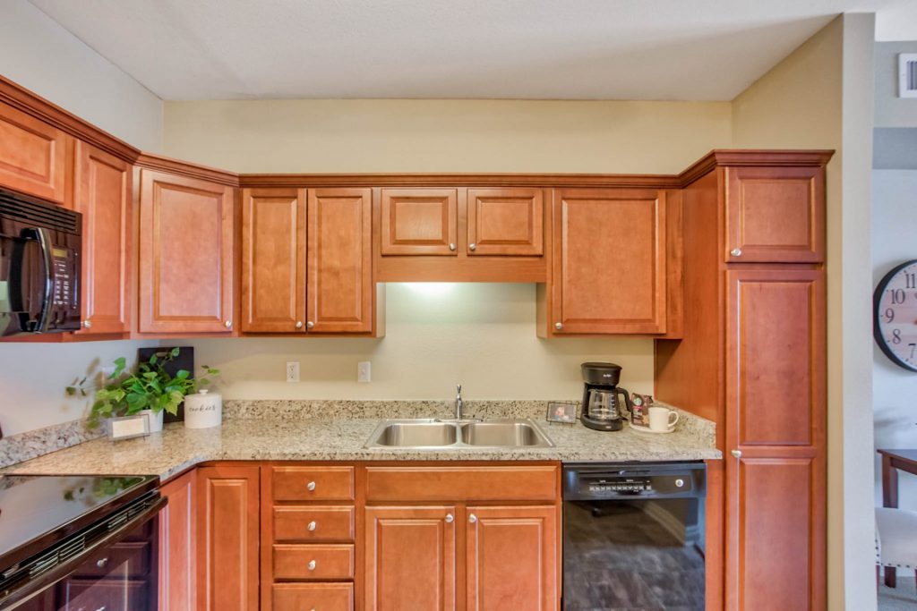 Modern kitchen with cherry wood cabinets, granite countertops, and various appliances.