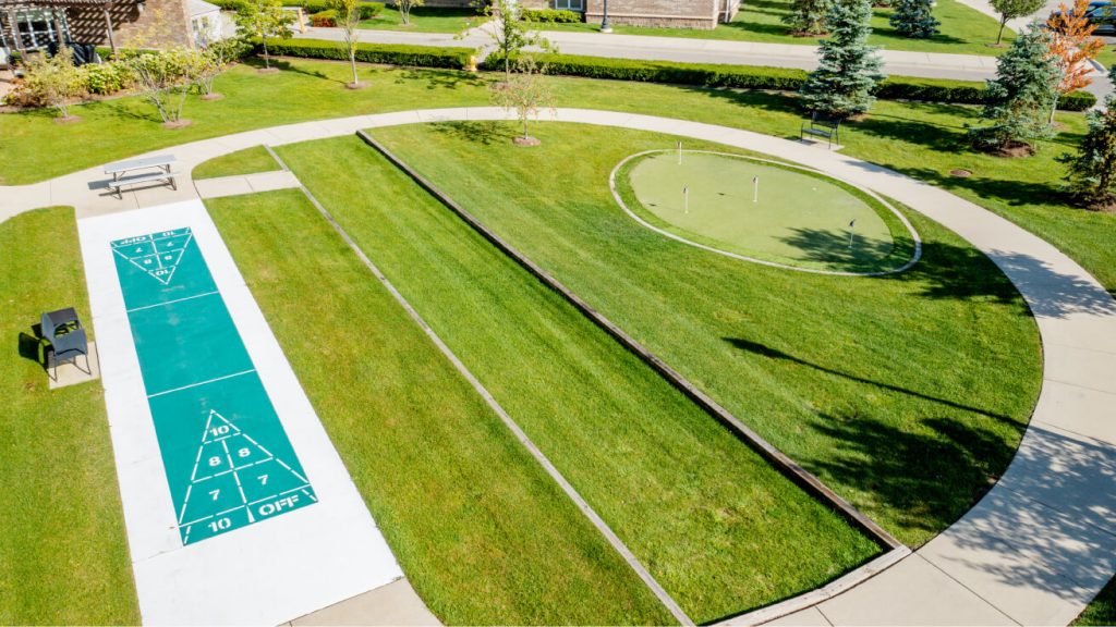 Aerial view of outdoor recreation area with shuffleboard court and putting green on grass