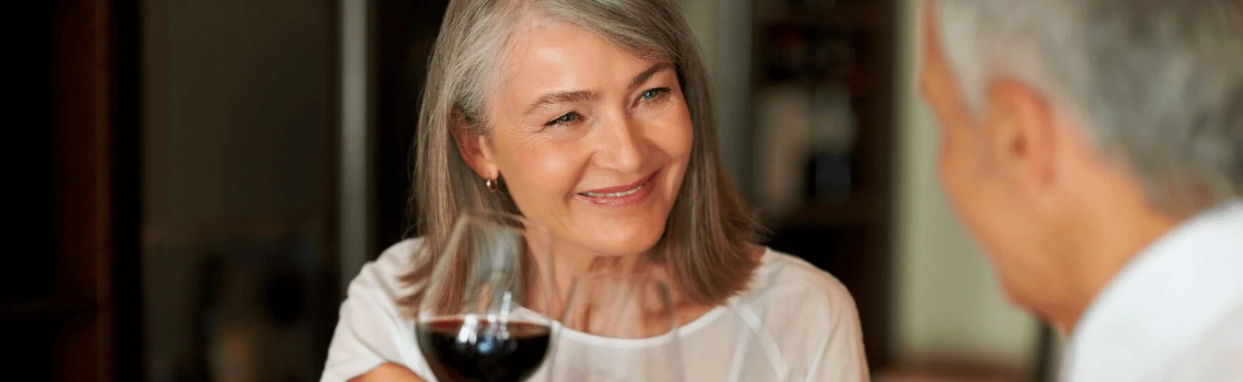 senior woman drinking wine with her husband
